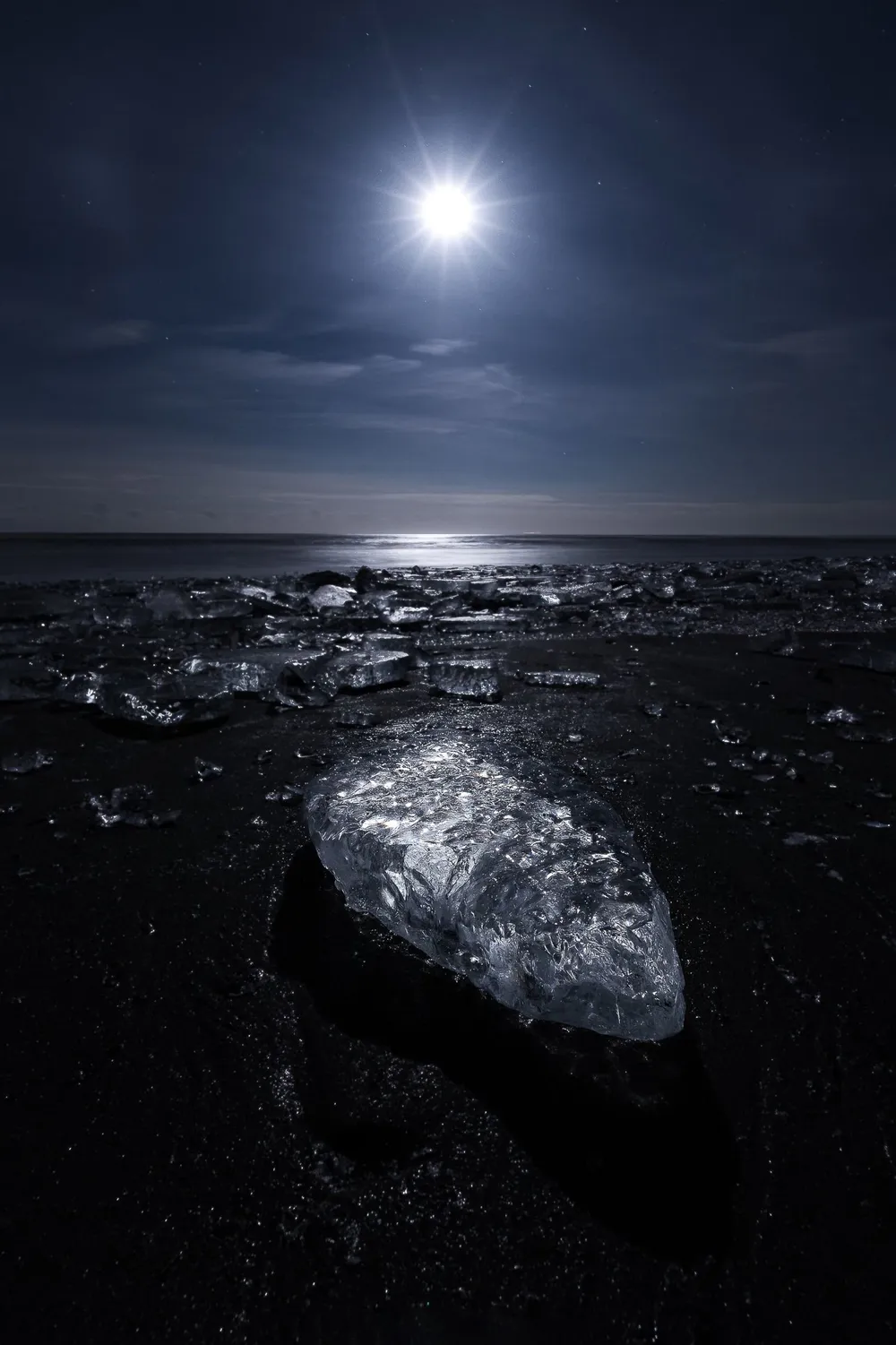Lua brilhando sobre o mar durante a noite, ambientação para o ritual de lua nova