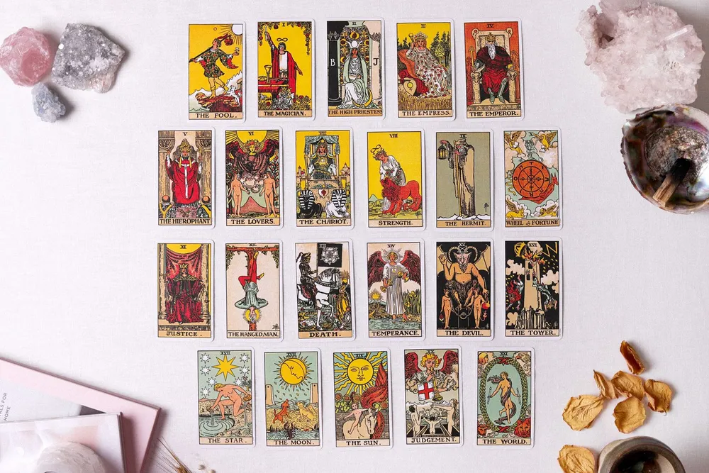 Cartas de tarot dos Arcanos Maiores espalhadas sobre a mesa, com cristais ao redor